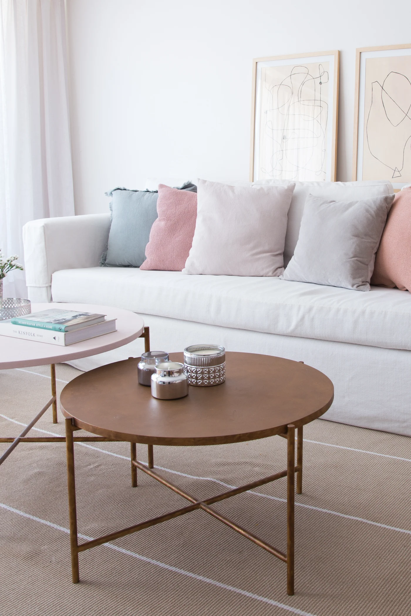 Sala de estar moderna con sofá blanco y mesas de café en capas.