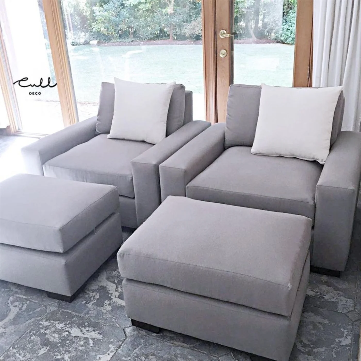 Sala de estar moderna con sillones modulares grises y mesas otomanas.