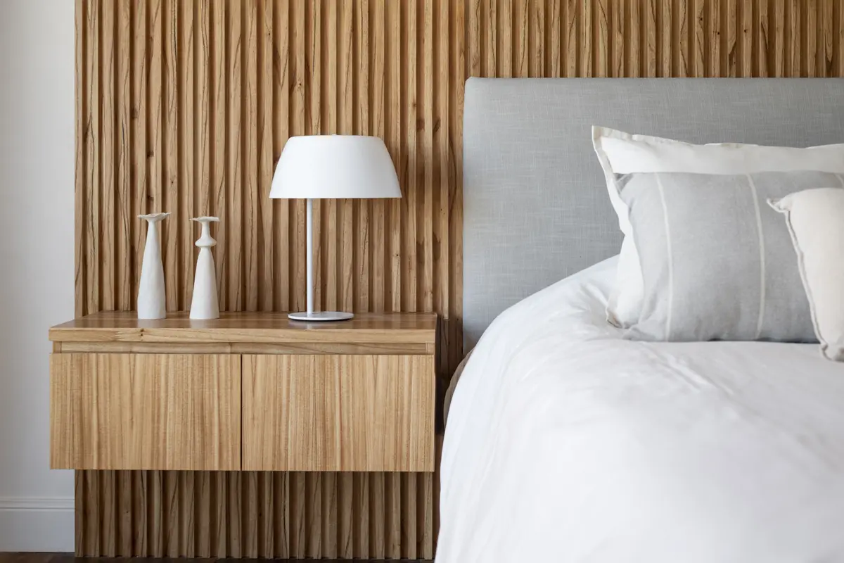 Dormitorio moderno con pared de lamas de madera y mesa de noche de diseño — proyecto Lacroze, por Estudio Basa, en CABA