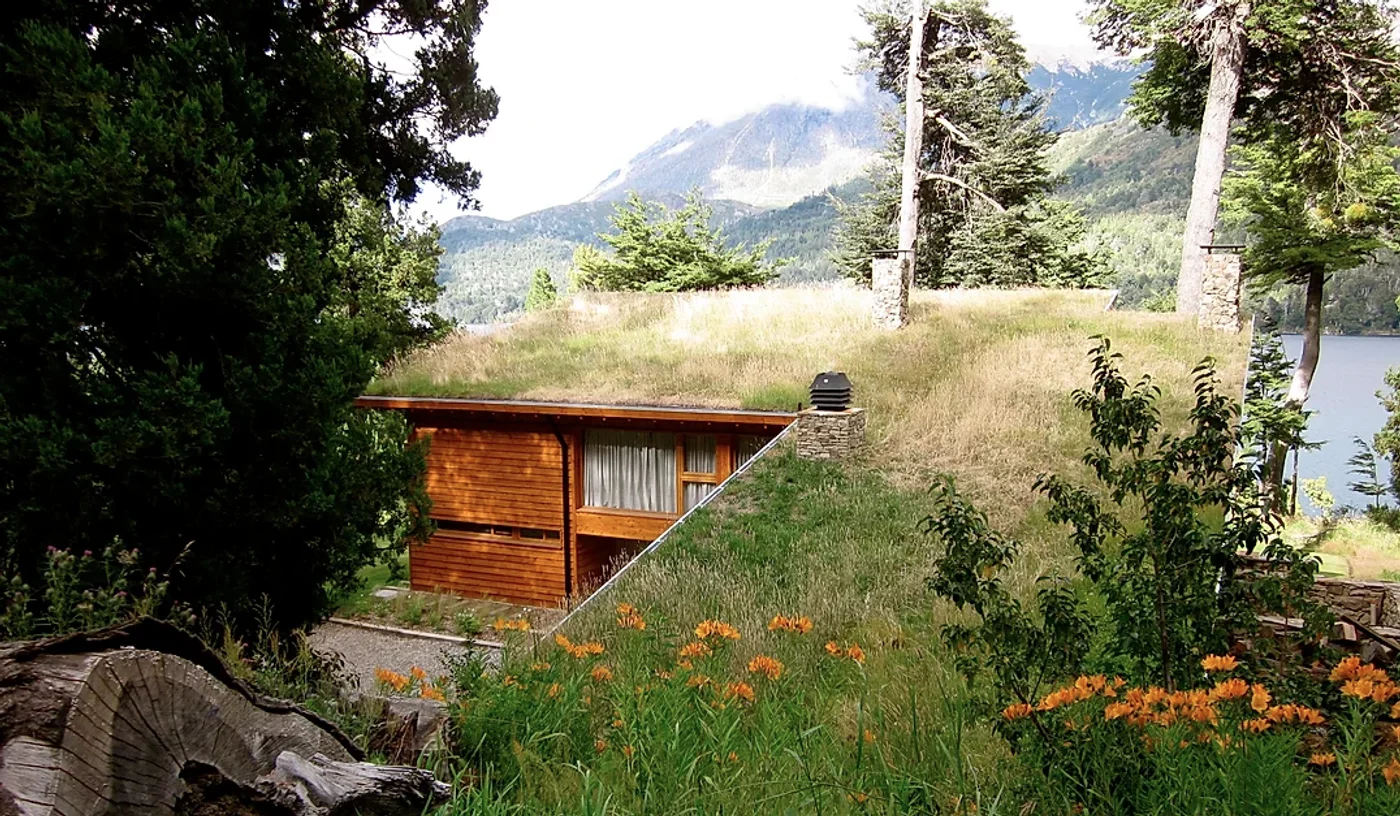Casa de madera con techo de pasto en montaña