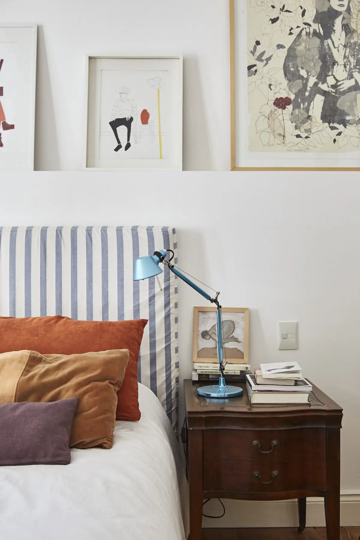 Dormitorio moderno con cama, lampara azul y cuadros — proyecto BERUTI 2, por Estudio Trama, en Palermo