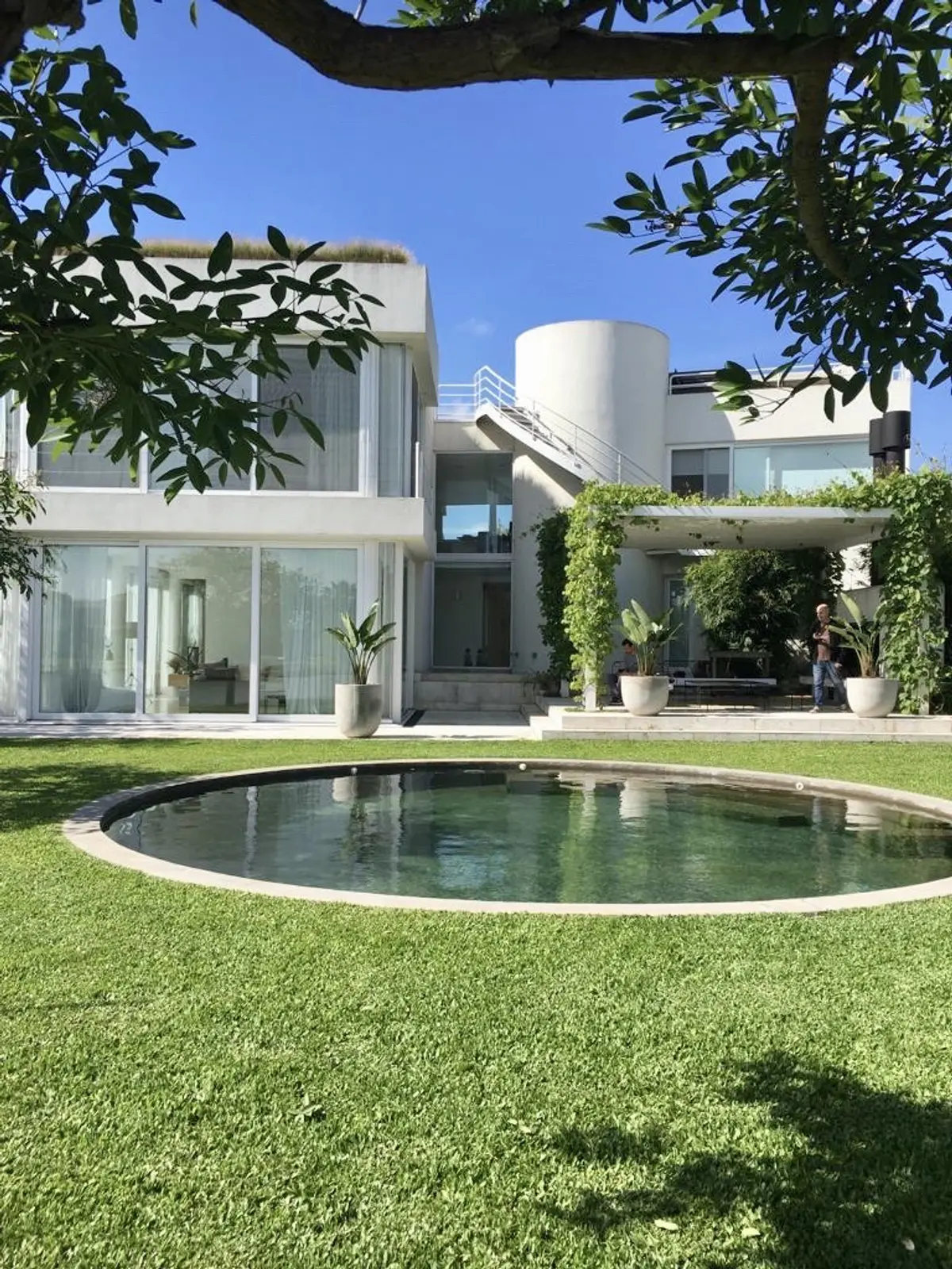 Casa moderna con piscina curva y jardines exuberantes — proyecto CASA LAGUNA, por Estudio Xime Fontan Balestra, en Tigre