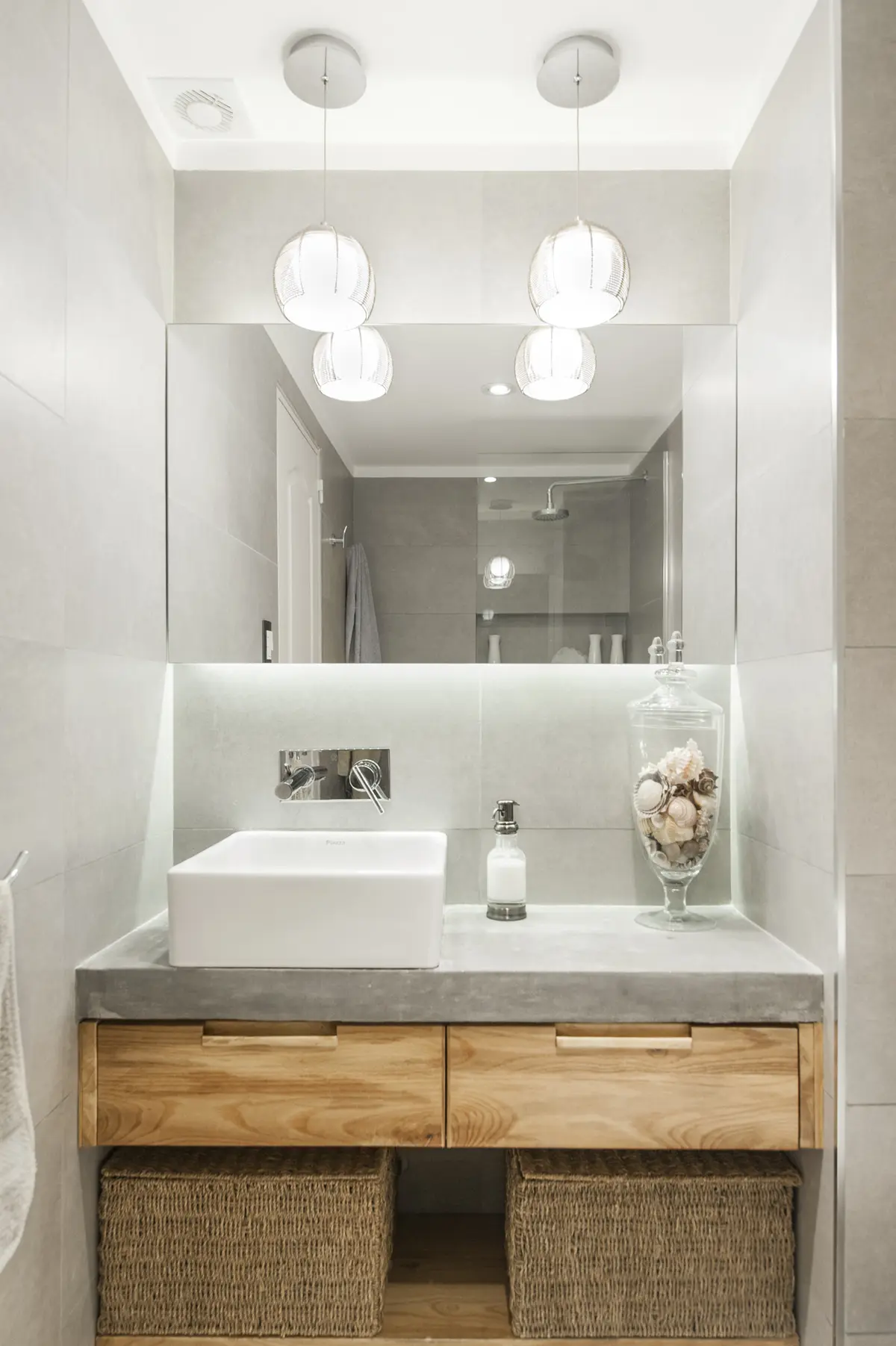 Baño moderno con bacha de apoyo, mesada de hormigón y muebles de madera — proyecto Arce 943, por ST Arquitectas, en CABA