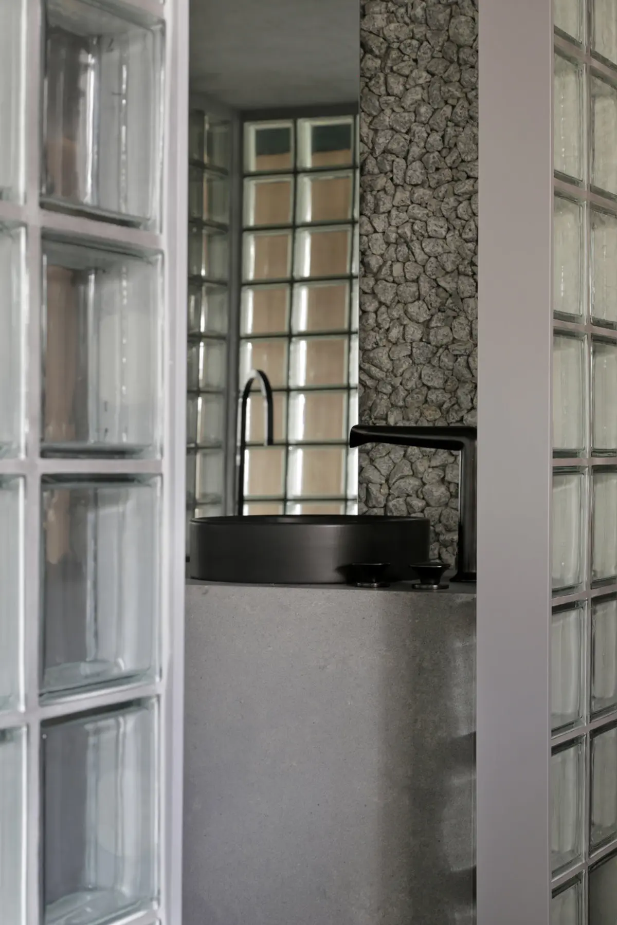 Pasillo con puertas vidriadas, pared texturada y mesada negra — proyecto Casa COR 2019, por Studio Ro-ca