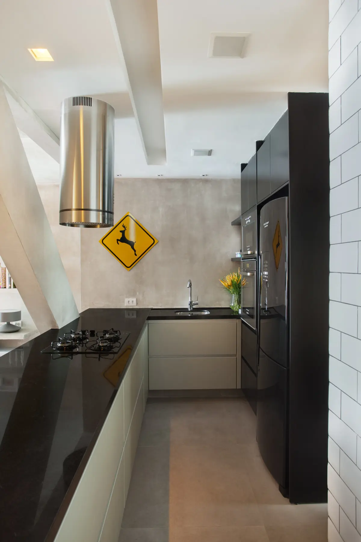 Cocina moderna con mesada negra, isla central y doble altura luminosa — proyecto MM House, por Studio Ro-ca