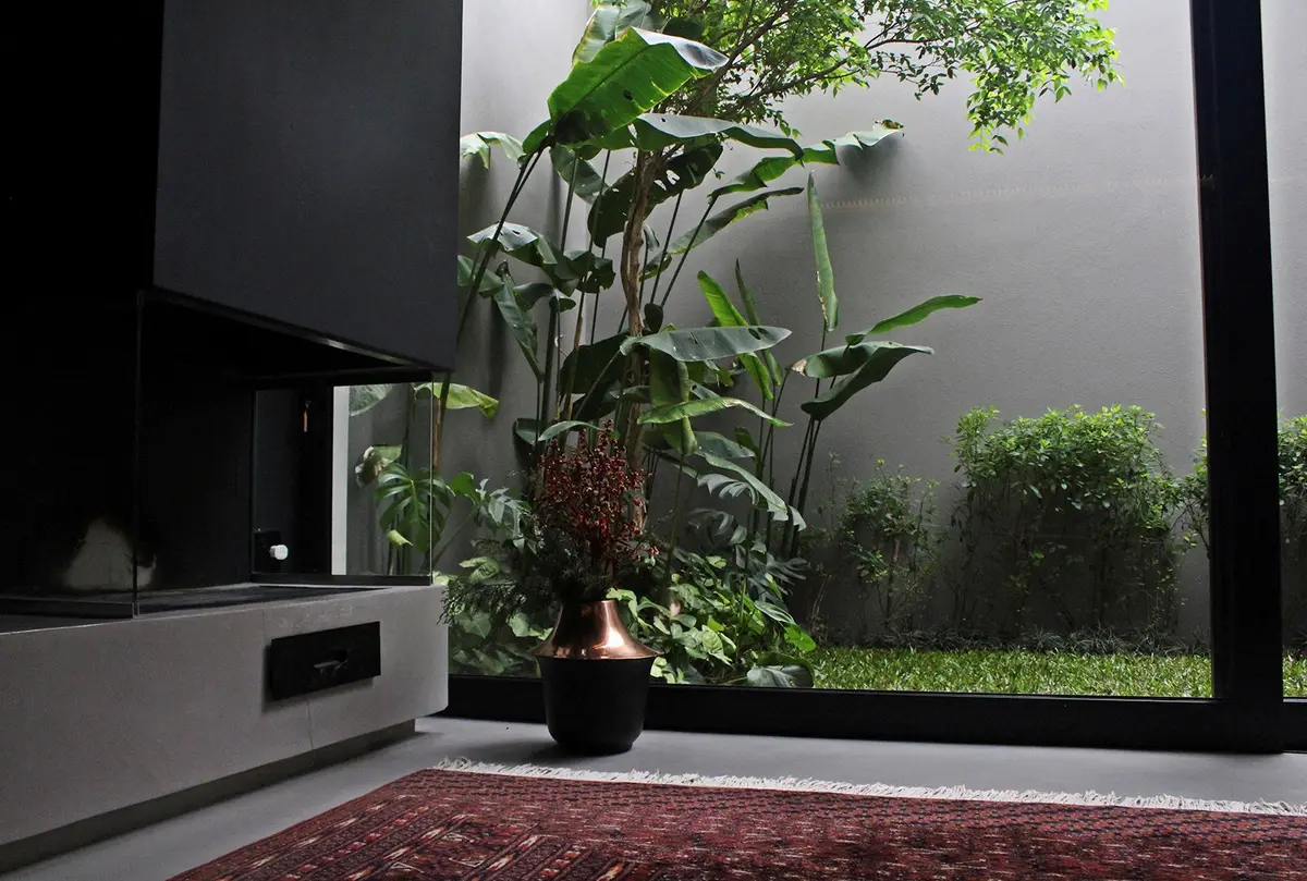 Patio interior con jardin vertical y gran ventanal minimalista — proyecto Residência HC, por Gil Fialho