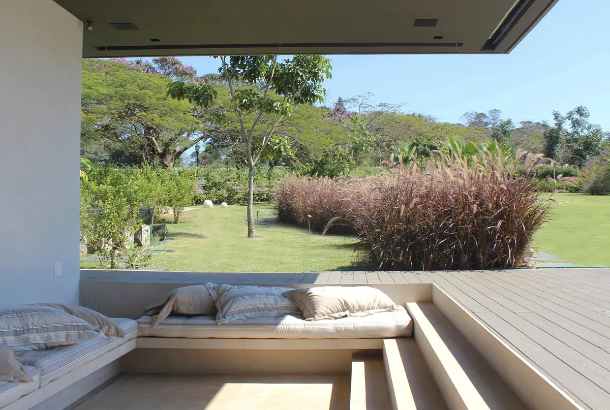 Terraza con deck de madera y vistas al jardín arbolado — proyecto Residência JY, por Gil Fialho
