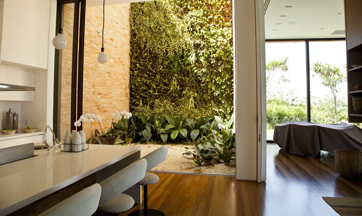 Cocina moderna con isla, jardín vertical y ventanales amplios — proyecto Residência MP, por Gil Fialho