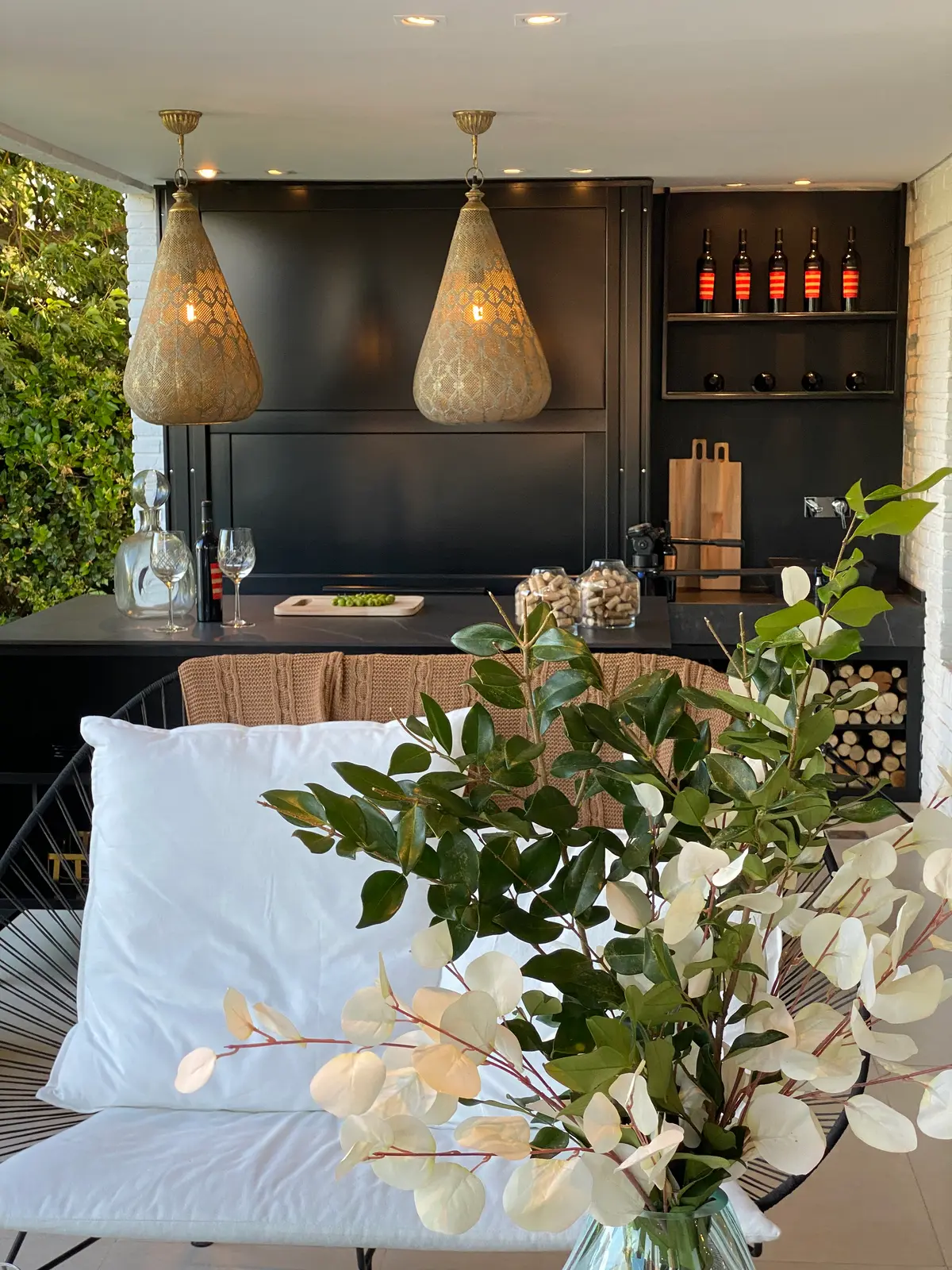 Terraza balcón semi-exterior con luces colgantes de cristal y plantas — proyecto GALERIA exterior para Design Life&Work, por Claudia Camisar Alterman y Adriana Teplixke
