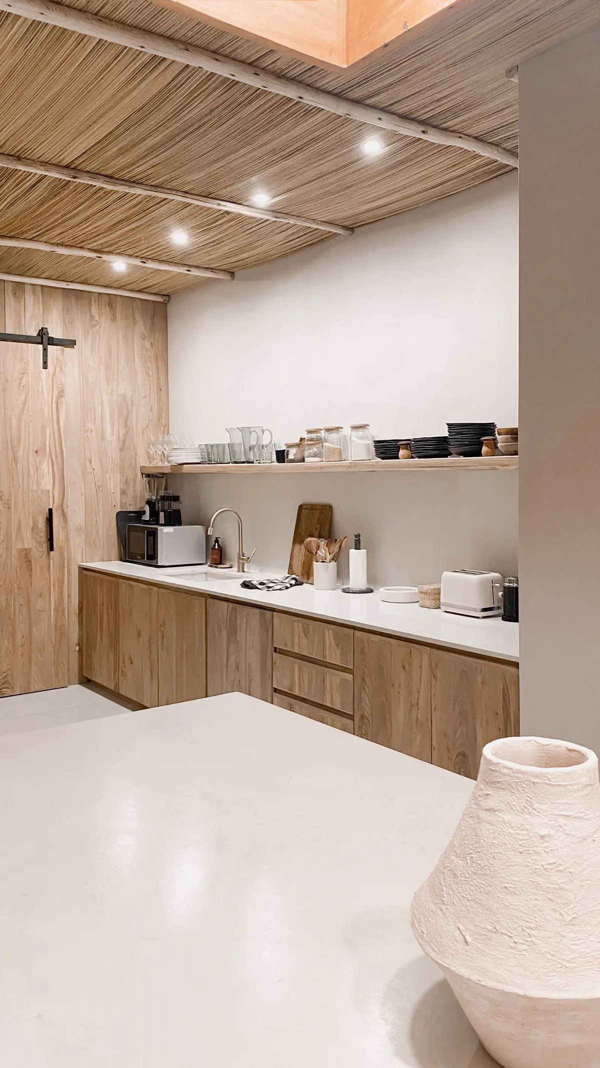 Cozinha moderna com detalhes rústicos e teto de madeira — projeto El Refugio, por Grupo Pauta Arquitectura, em Pinamar