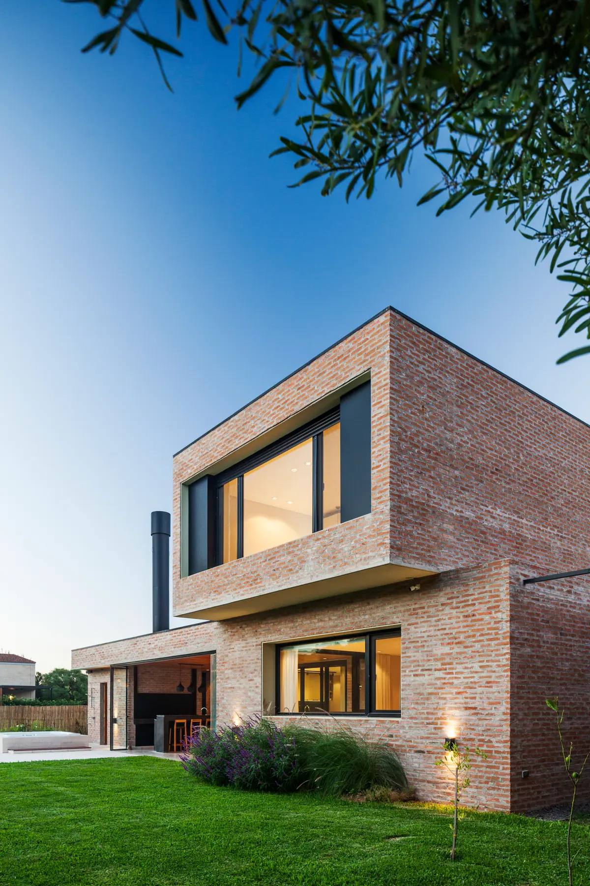 Casa moderna de ladrillos con grandes ventanales y jardín — proyecto Casa Brick, por LSA. , en Pilar