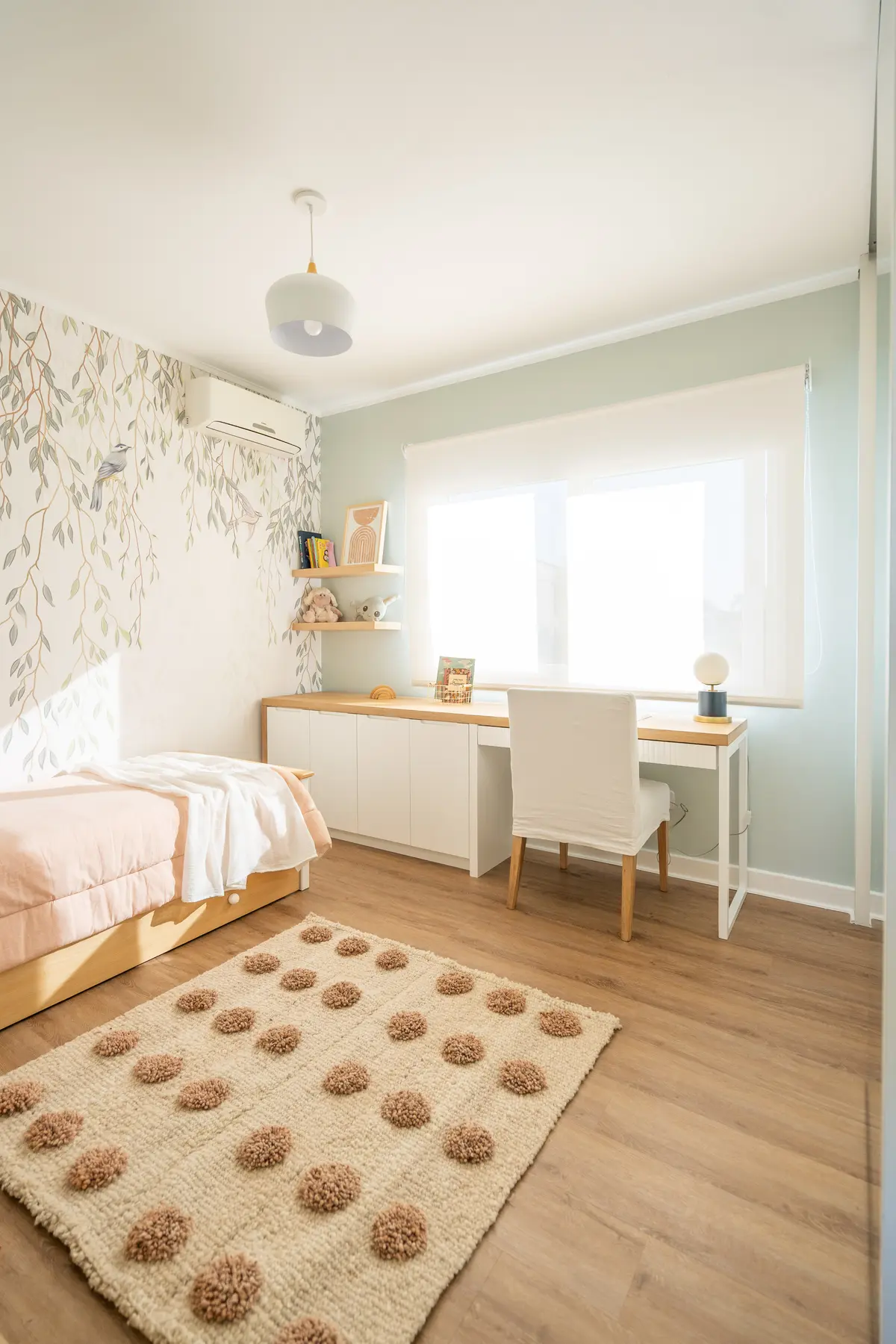 Quarto escandinavo com papel de parede botânico e tapete de pompons — projeto El Atardecer - Dormitorio Elo, por Blue Rabbit Design, em Rincón de Milberg