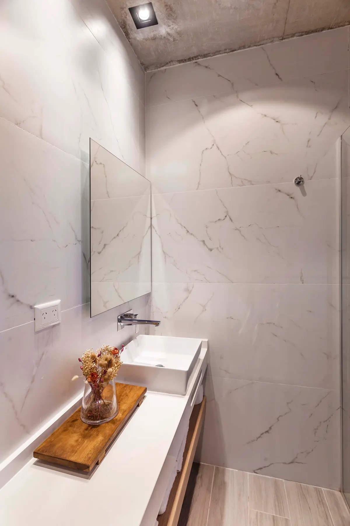 Banheiro moderno com parede em mármore e teto de concreto — projeto DISEÑO INTERIOR - CASA VISTAS, por FOCO_arquitectura&diseñointerior, em Belén de Escobar