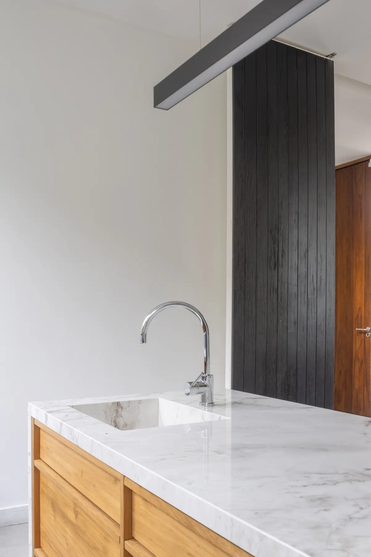 Cocina moderna con isla de mármol, madera y panelado de listones — proyecto CASA OrAz, por Alfredo Orfila arquitectura, en San Isidro