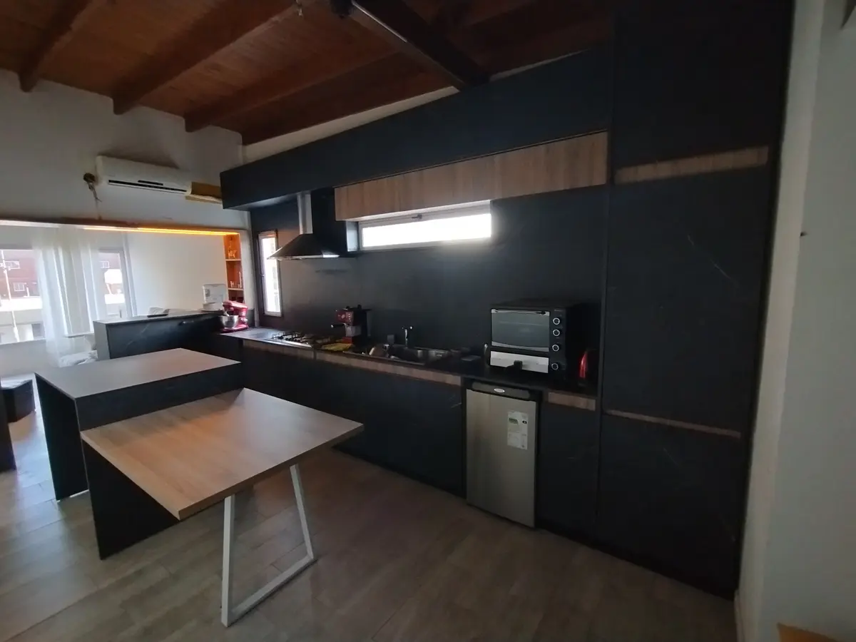 Cozinha moderna com ilha, armários pretos e detalhes em madeira — projeto Diseño personalizado a gusto del cliente, por Saavedra Amoblamientos, em Pinamar