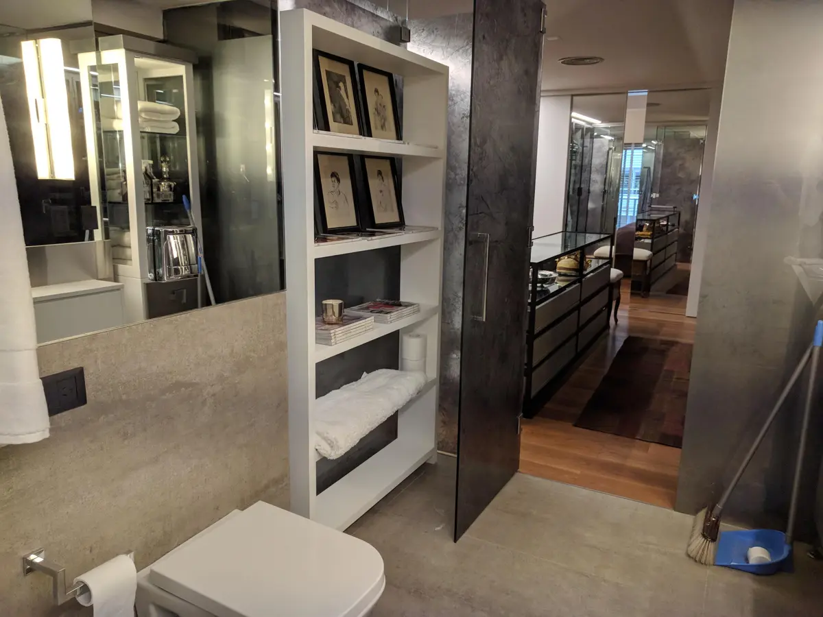 Baño moderno con estanterías blancas empotradas y paredes de microcemento gris — proyecto AT - Departamento en Palermo, por MLS Estudio, en Palermo