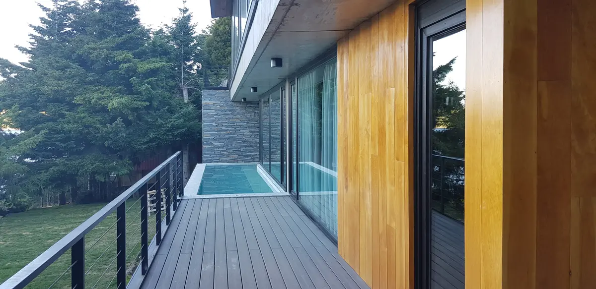 Terraço moderno com piscina integrada e revestimento de madeira — projeto Casa Península San Pedro, por Servente Larrazabal Arq, em Bariloche