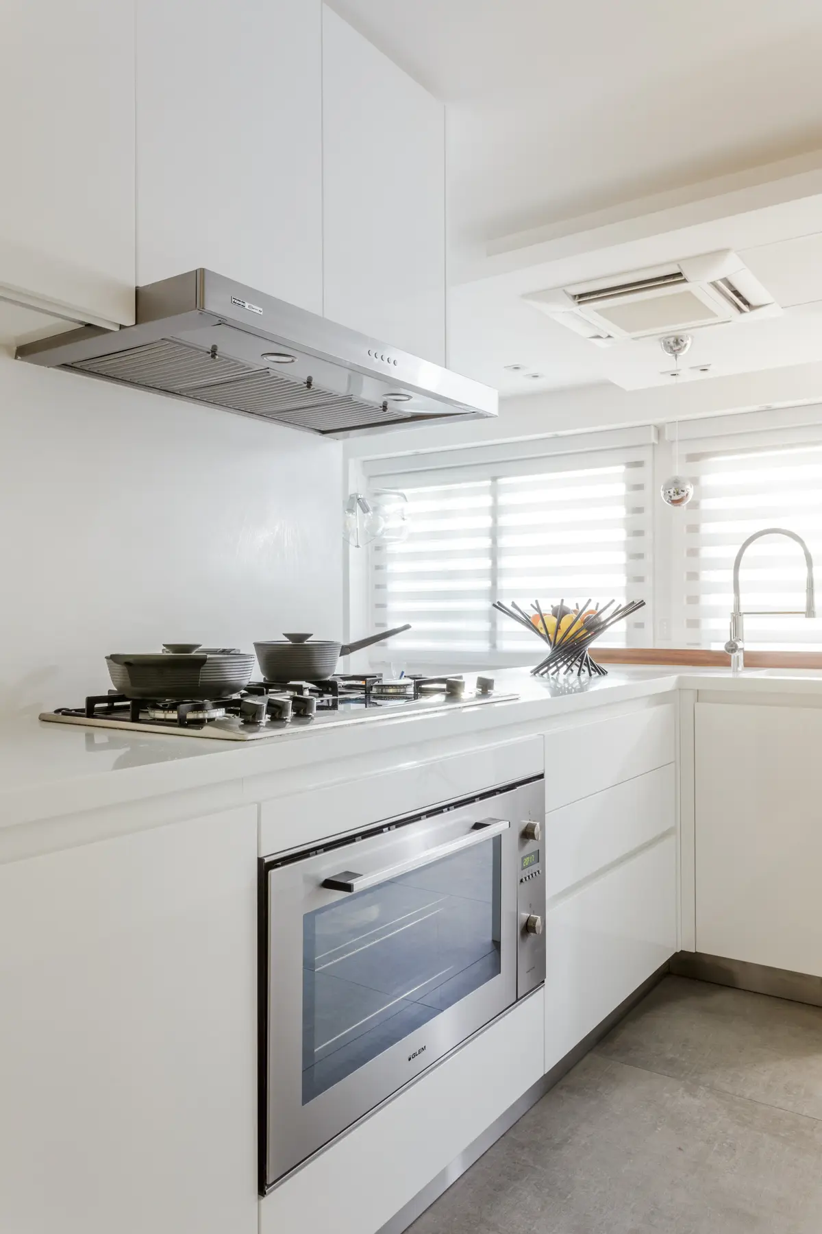 Cocina moderna minimalista con gabinetes blancos y electrodomésticos integrados — proyecto Piso en Belgrano, por Gutman+Lehrer Arquitectas, en Belgrano