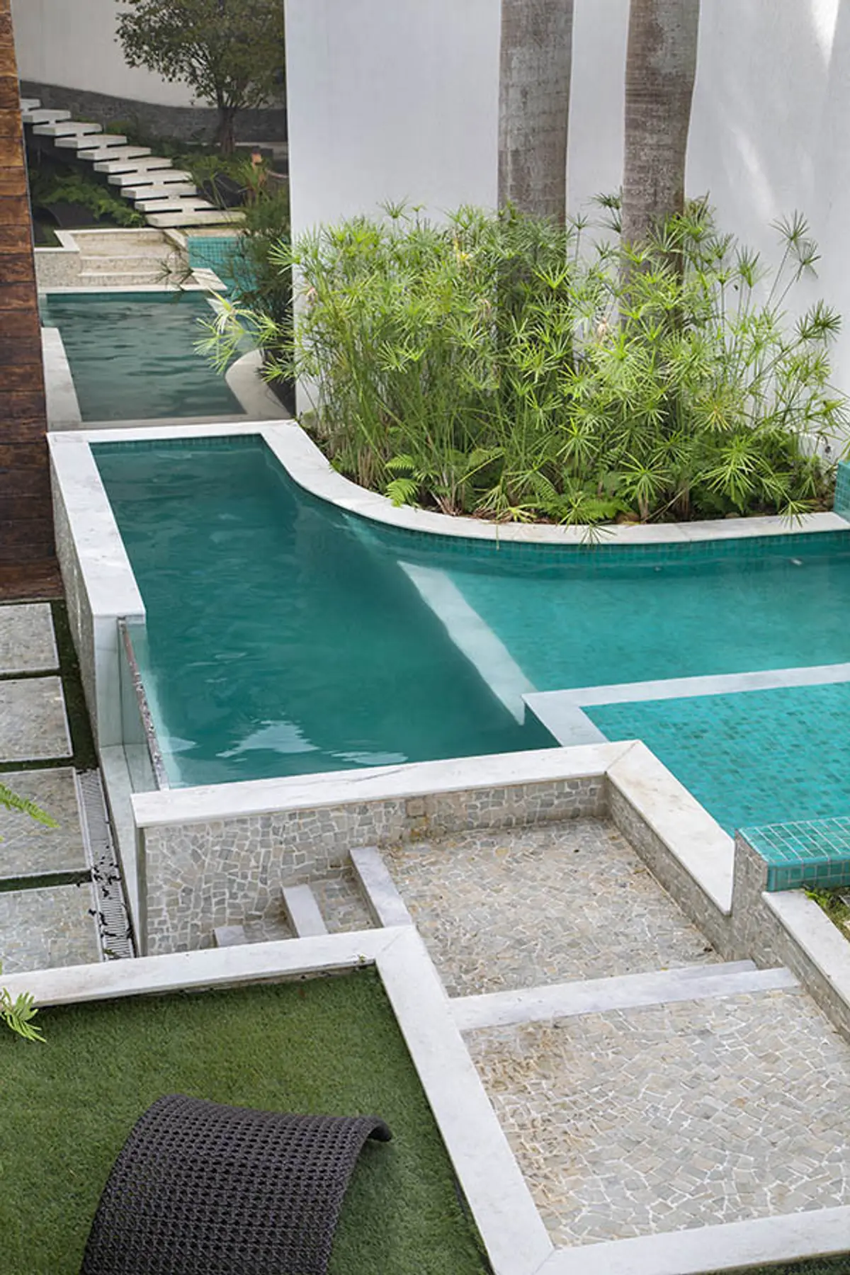 Patio minimalista con piletas conectadas, plantas y escaleras de piedra — proyecto Casa Jardim Guanabara, por Amanda Miranda