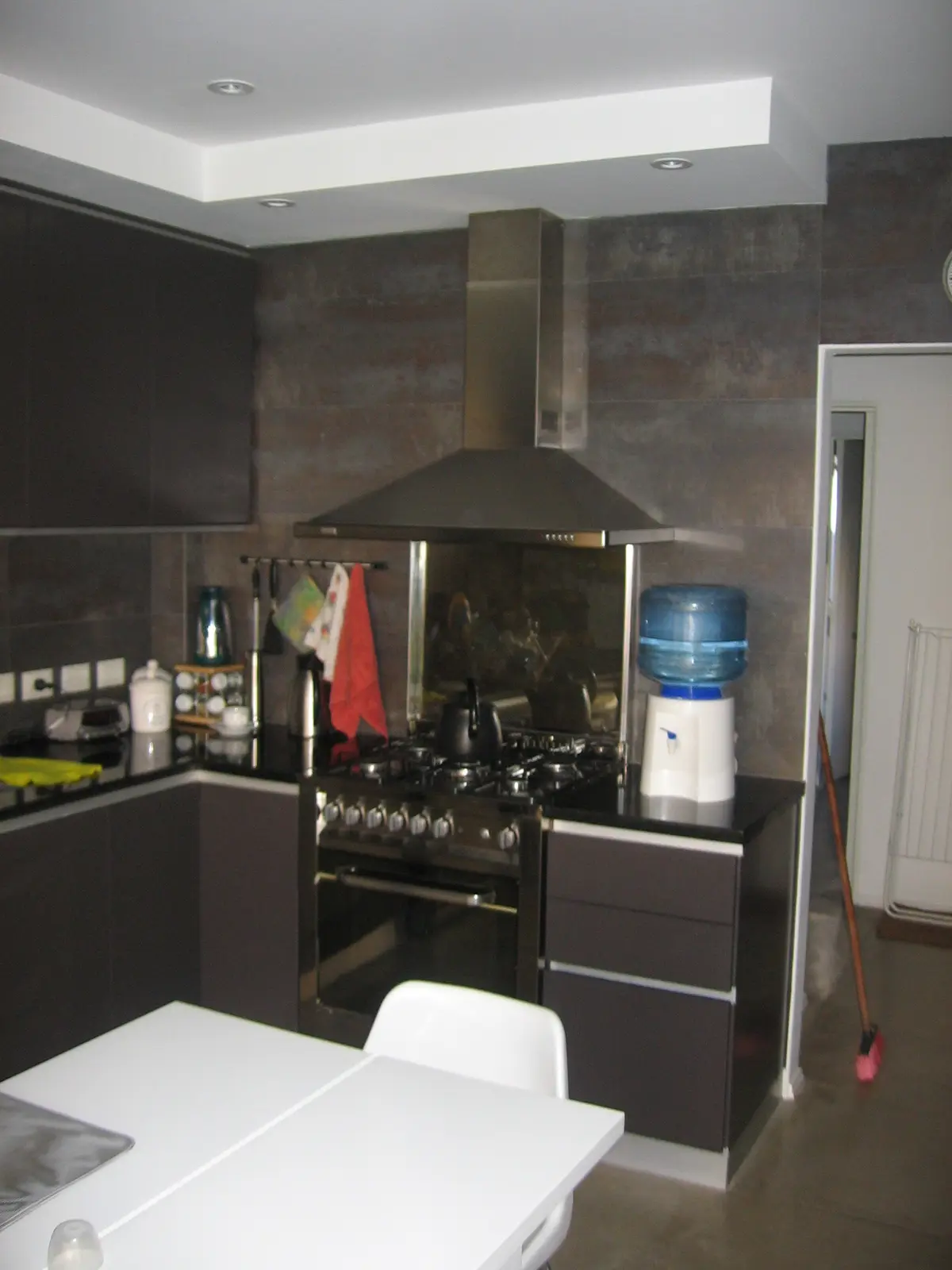 Cocina moderna con muebles negros, campana negra y techo blanco — proyecto San Isidro, por Rioja Arquitectura, en San Isidro