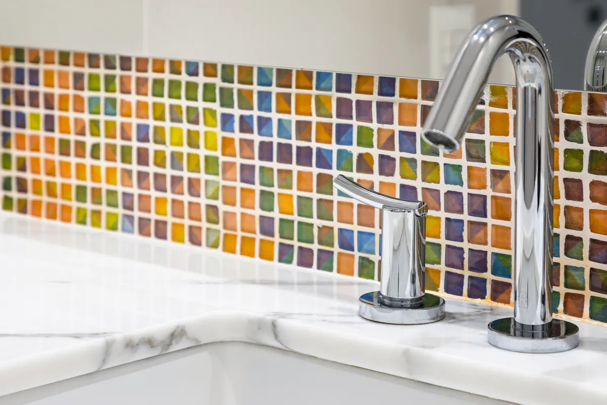 Torneira moderna sobre respingo de mosaico colorido — projeto Baño en Belgrano, por MARCO GUOLI PHOTO, em Belgrano