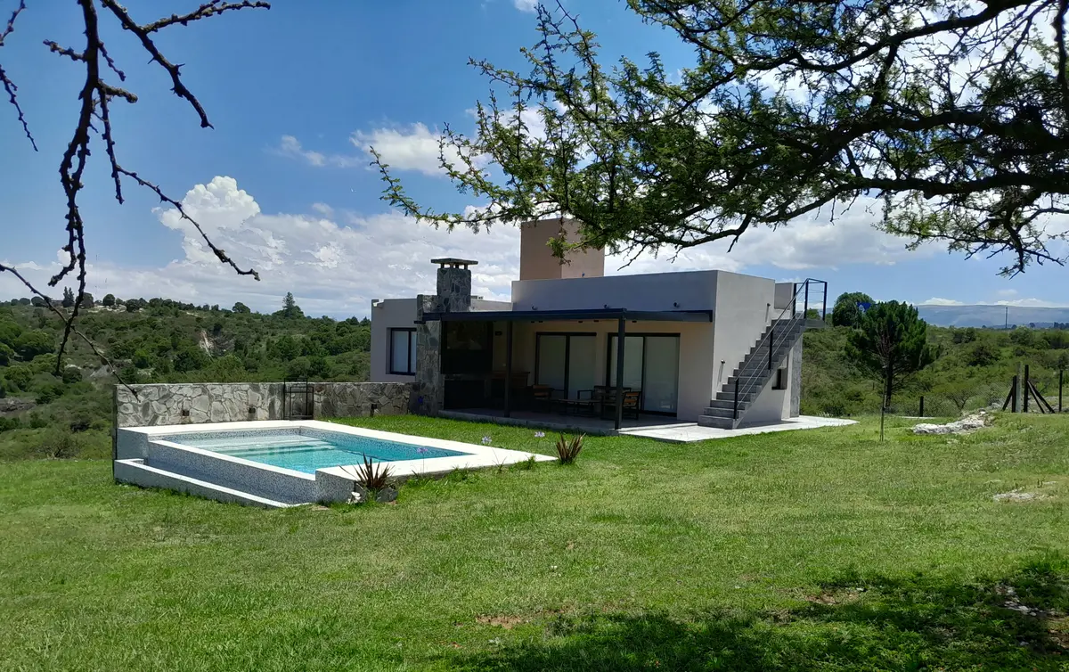 villa moderna com fachada de pedra e piscina — projeto Complejo de Cabañas en Potrero de Garay, Córdoba, por ESTUDIO ARQ.GABRIEL ARIAS, em Córdoba