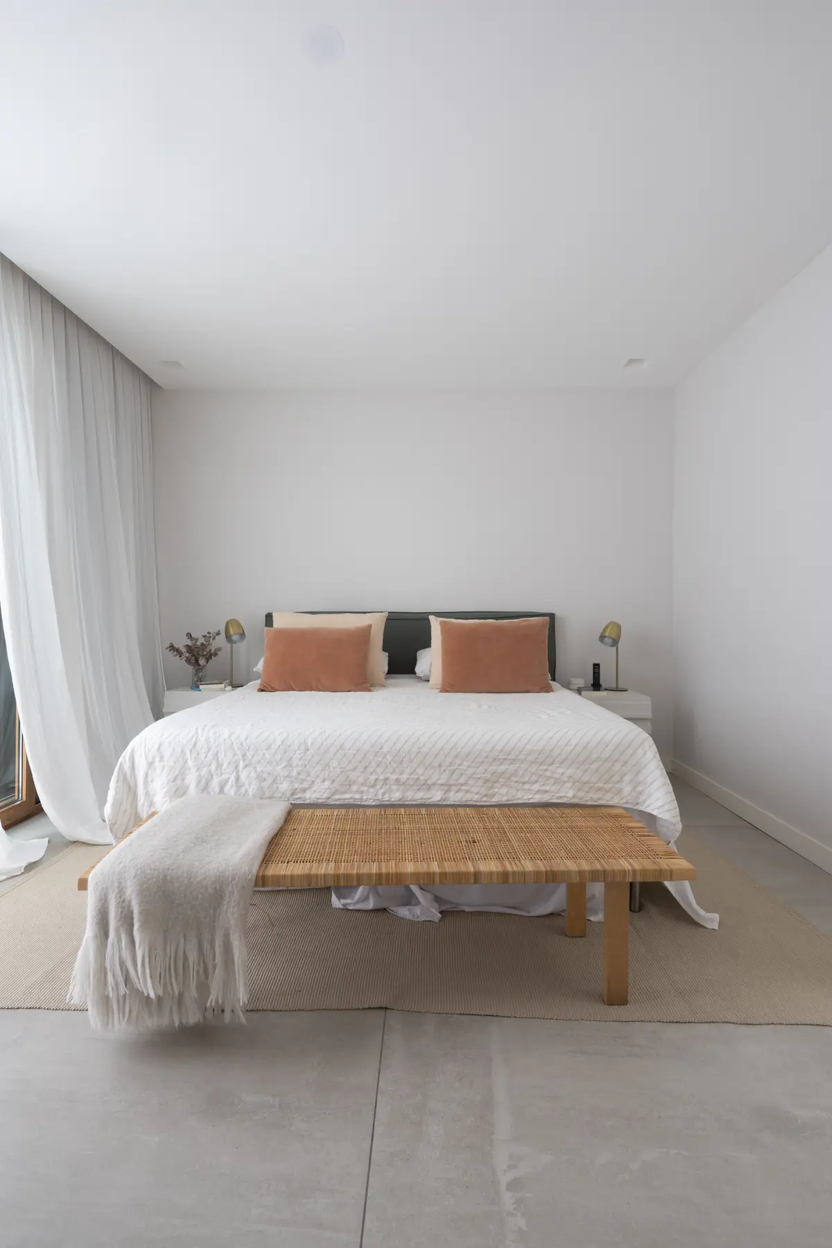Dormitorio minimalista con cortinas de tela blanca y banco de ratán — proyecto CASA OrAz, por Alfredo Orfila arquitectura, en San Isidro