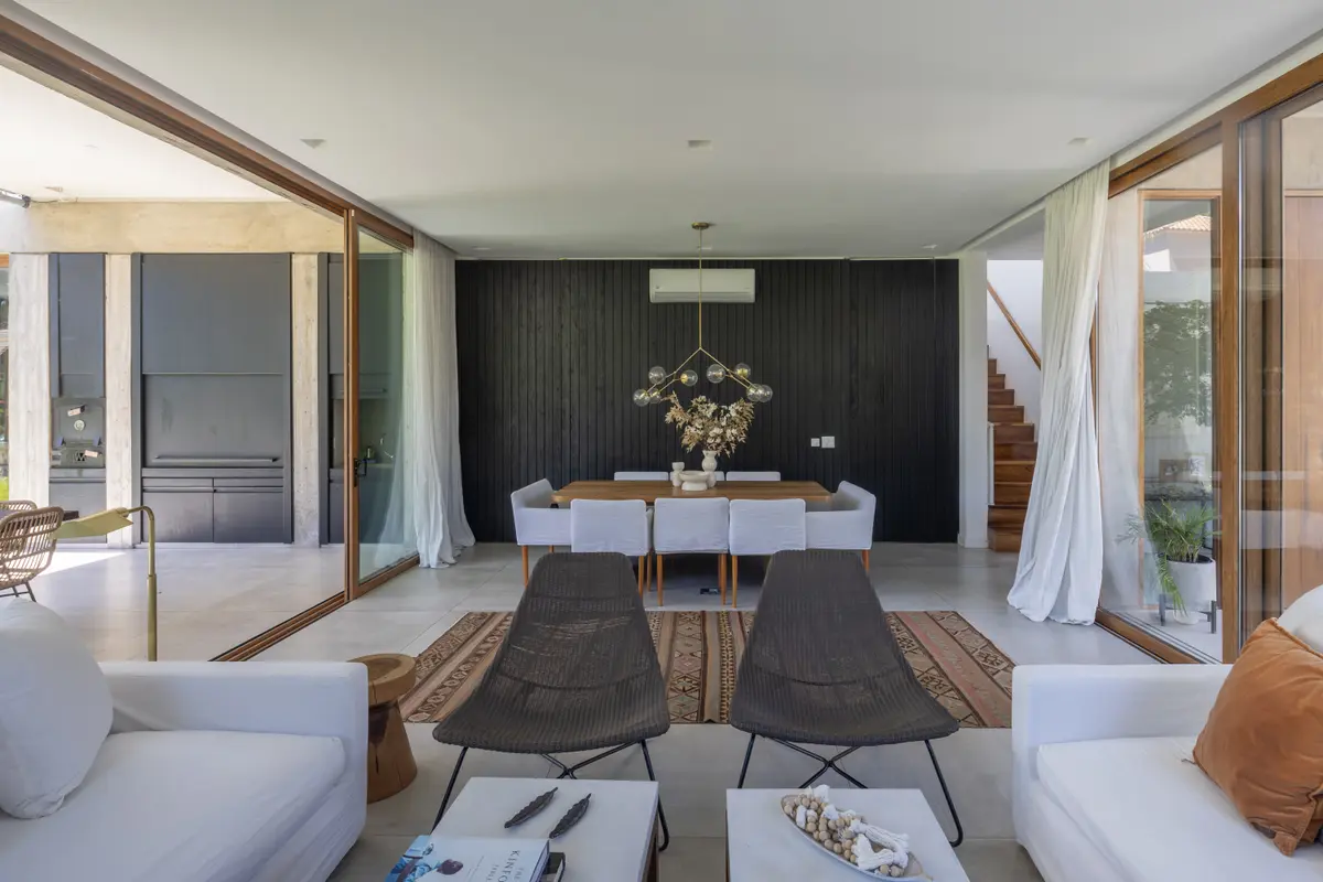 Living moderno con pared de madera negra y mucha luz — proyecto CASA OrAz, por Alfredo Orfila arquitectura, en San Isidro