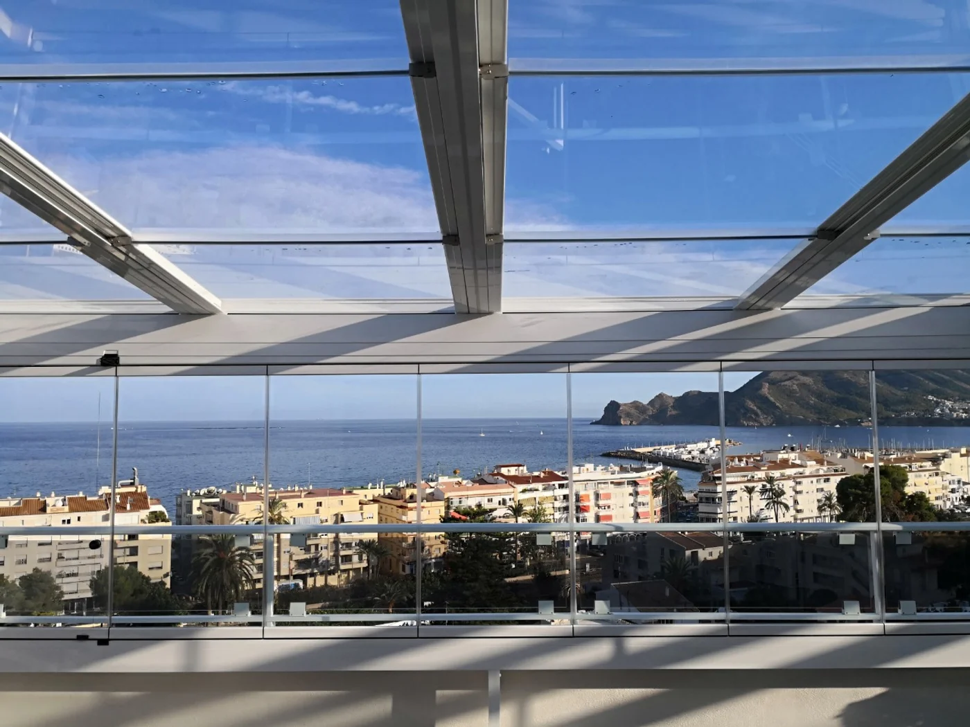 Terraza moderna con cerramiento de vidrio y vista al mar