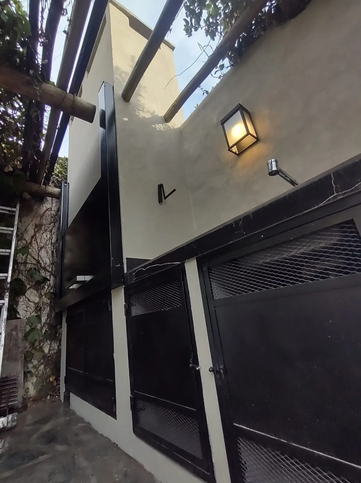 Fachada moderna com pergolado de madeira e iluminação externa — projeto Don Bosco, por MC Deco, em San Isidro