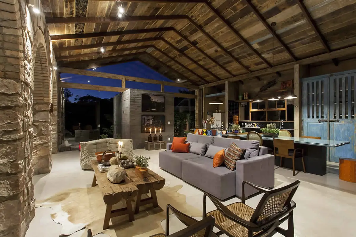Amplia galeria techada con living, techo madera y vistas nocturnas — proyecto Living, por Xico Diniz