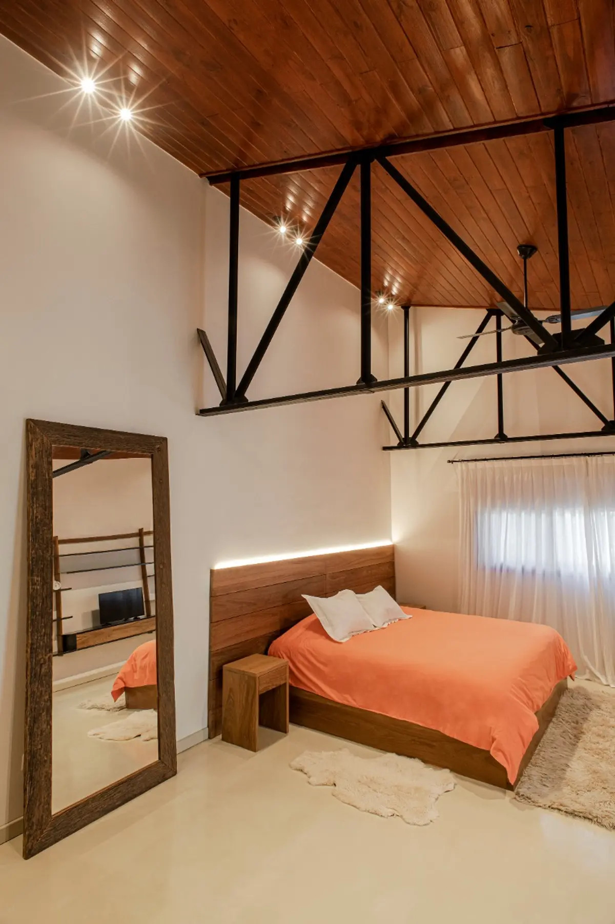 dormitorio industrial con vigas expuestas y techo de madera — proyecto Loft y garage autos de colección , por Arq. Damian Fainzilber, en San Isidro