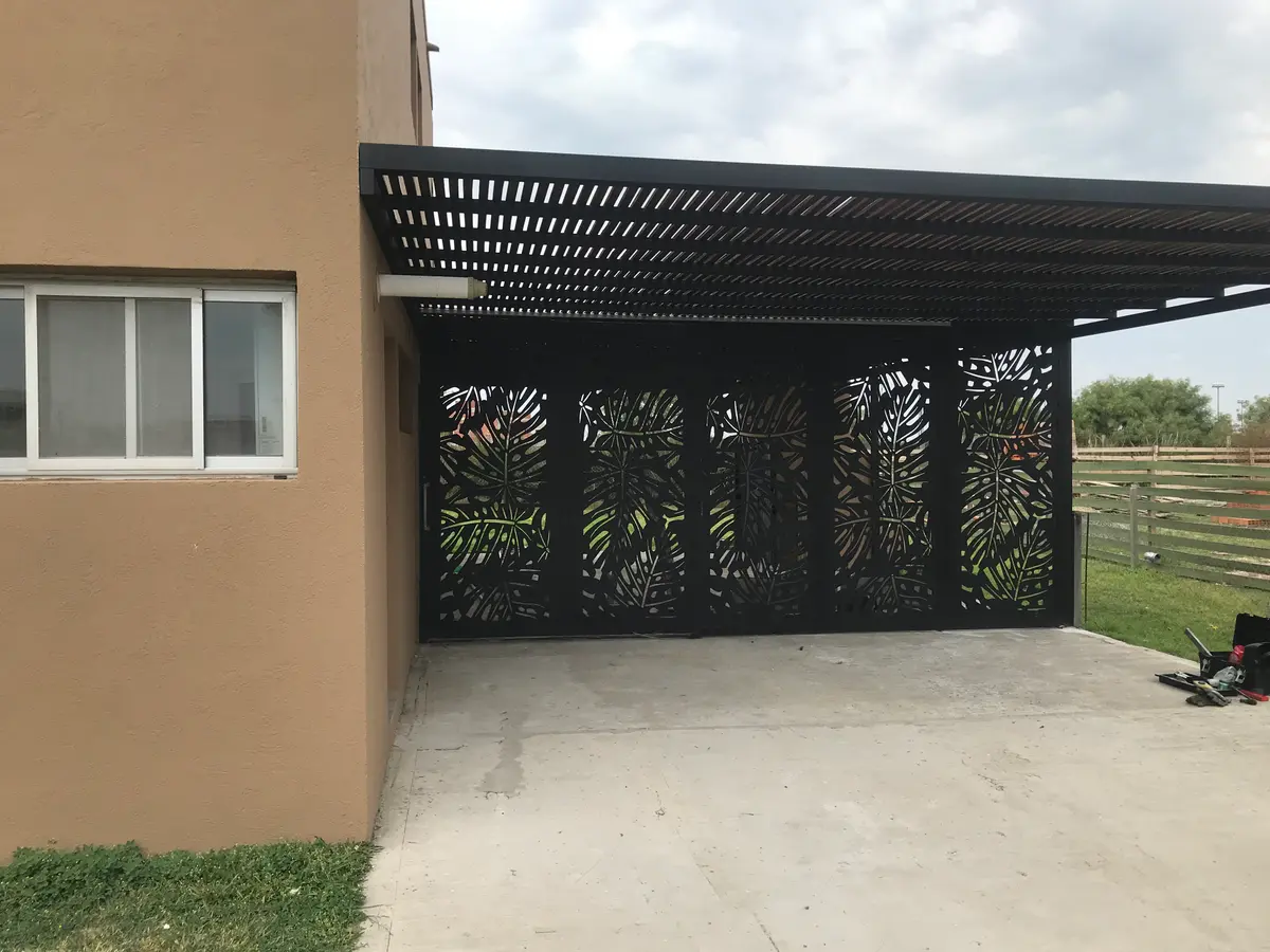 fachada moderna com pérgola e telas metálicas decorativas — projeto Chapa calada decorativa, tríptico árbol de la vida oara portones corredizos y ce, por Pintastic, em Belén de Esc