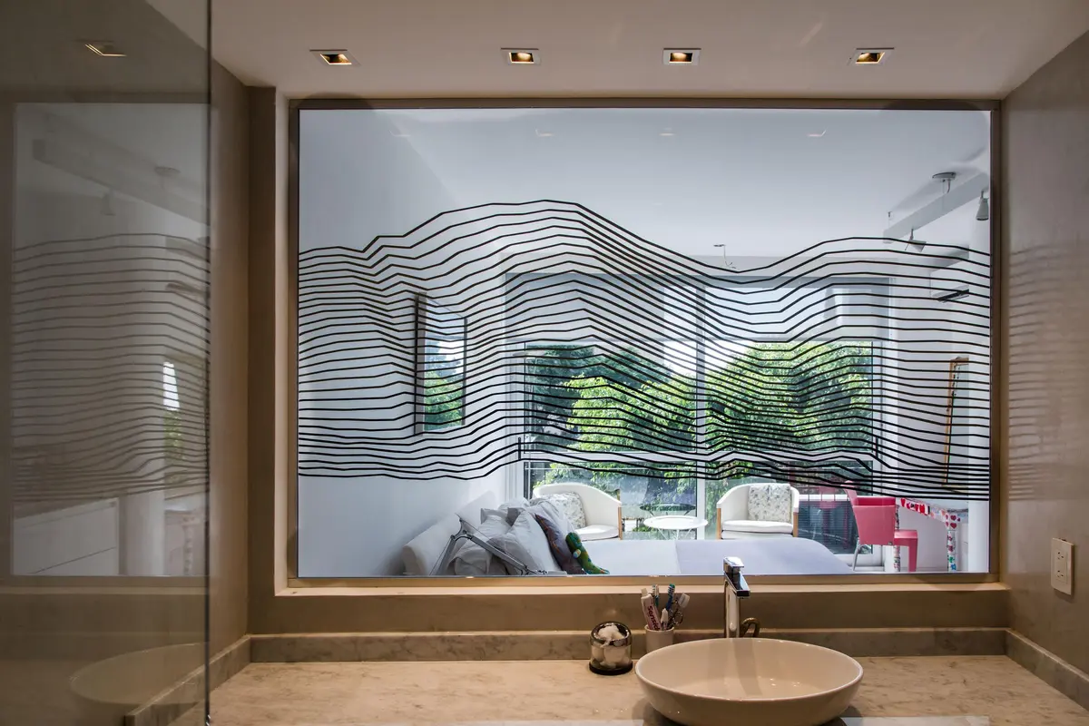 Baño moderno con gráfica wave en ventana y vanitory de piedra — proyecto Departamento Figueroa Alcorta, por Claudia Faena Studio, en CABA