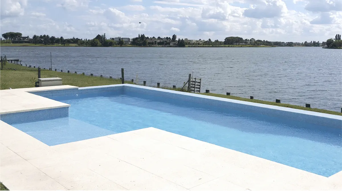 Piscina moderna en lote costero junto a un lago — proyecto CASA NORDELTA, por Alejandra Pan Arquitectura, en Nordelta