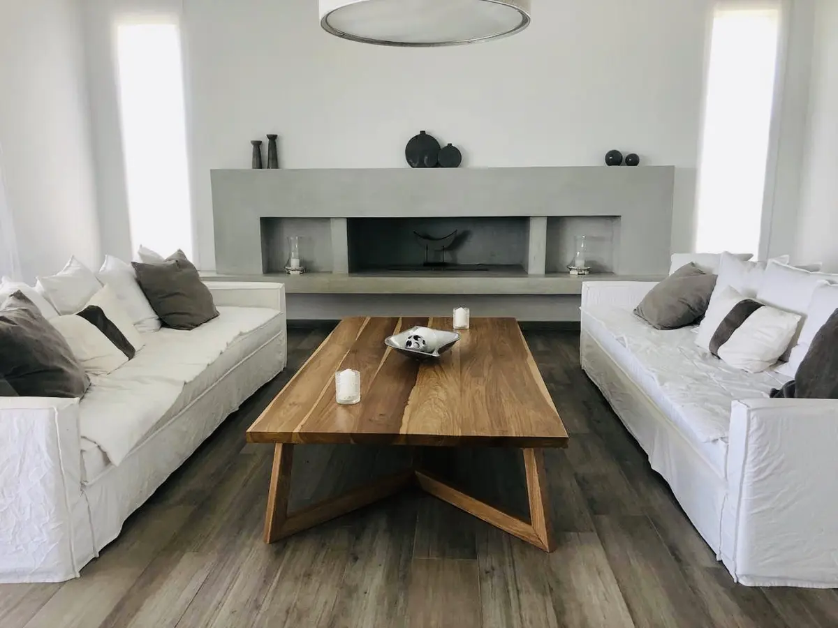 Sala de estar moderna com lareira e sofá branco — projeto Nordelta, por Greschek Obras, em Nordelta