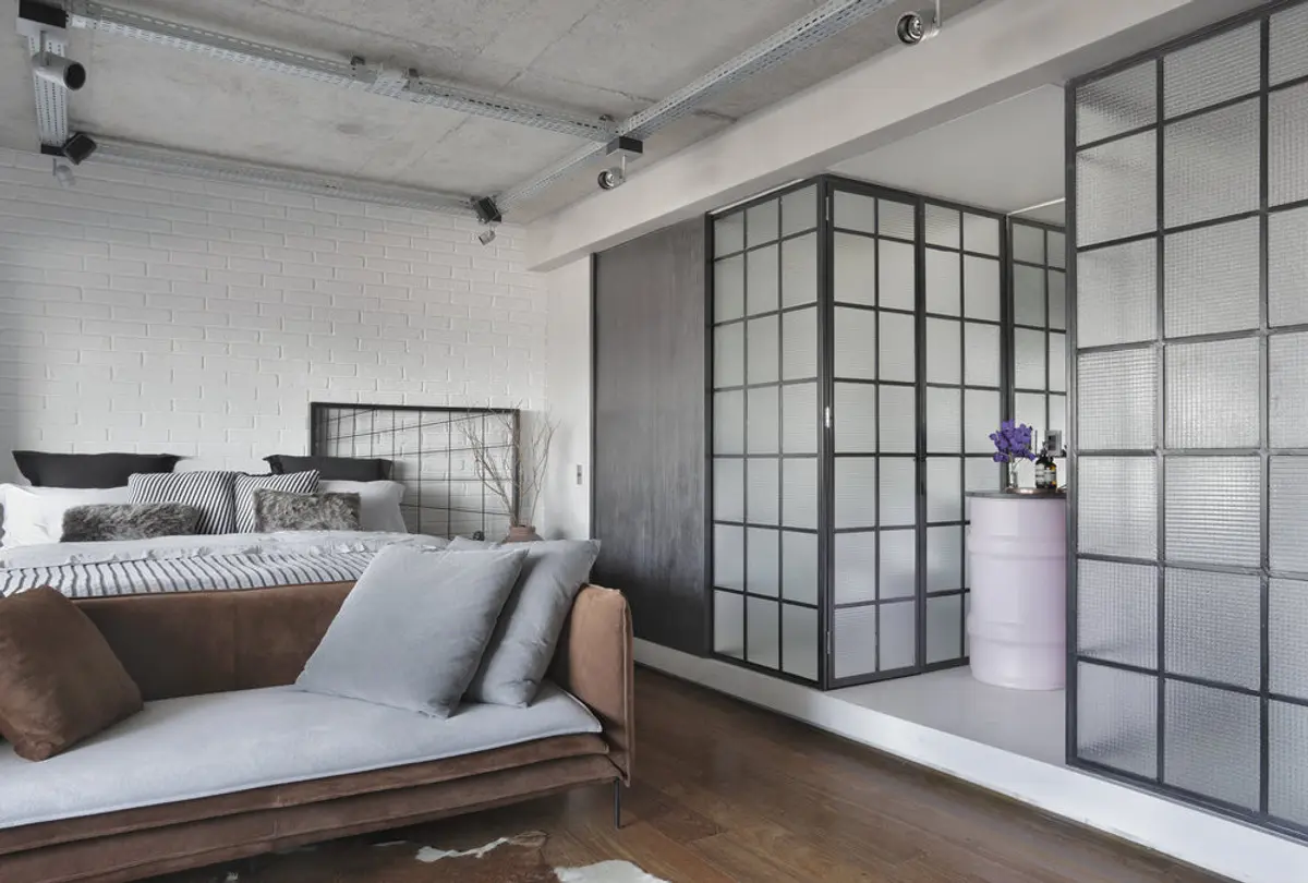 Dormitorio moderno con cama de madera, divisor vidrio y piso de parqué — proyecto RA Loft, por Studio Ro-ca