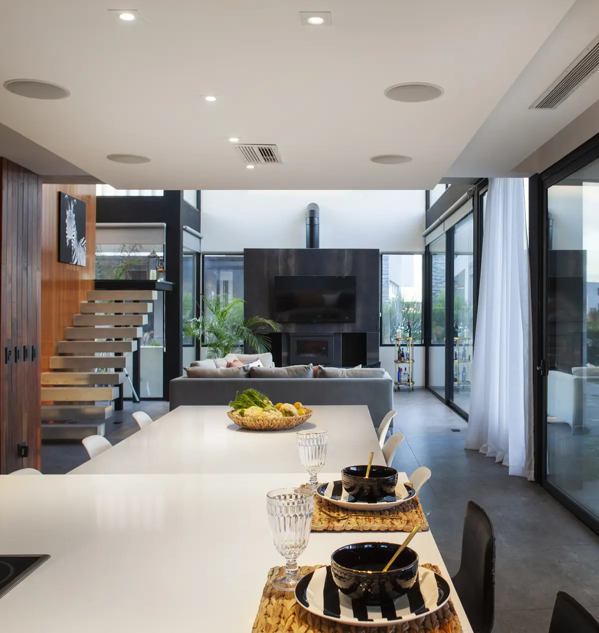 Sala de estar moderna e aberta com escada flutuante e lareira — projeto Casa BJM, por Vanguarda Arquitectos, em Belén de Escobar