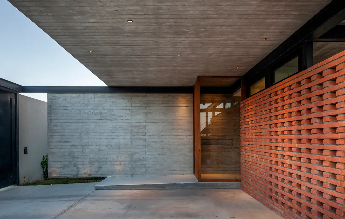 Fachada de casa moderna com tijolos perfurados e concreto — projeto CASA BSB, por BUSCETTI & DI BERNARDO arquitectas, em Gonnet