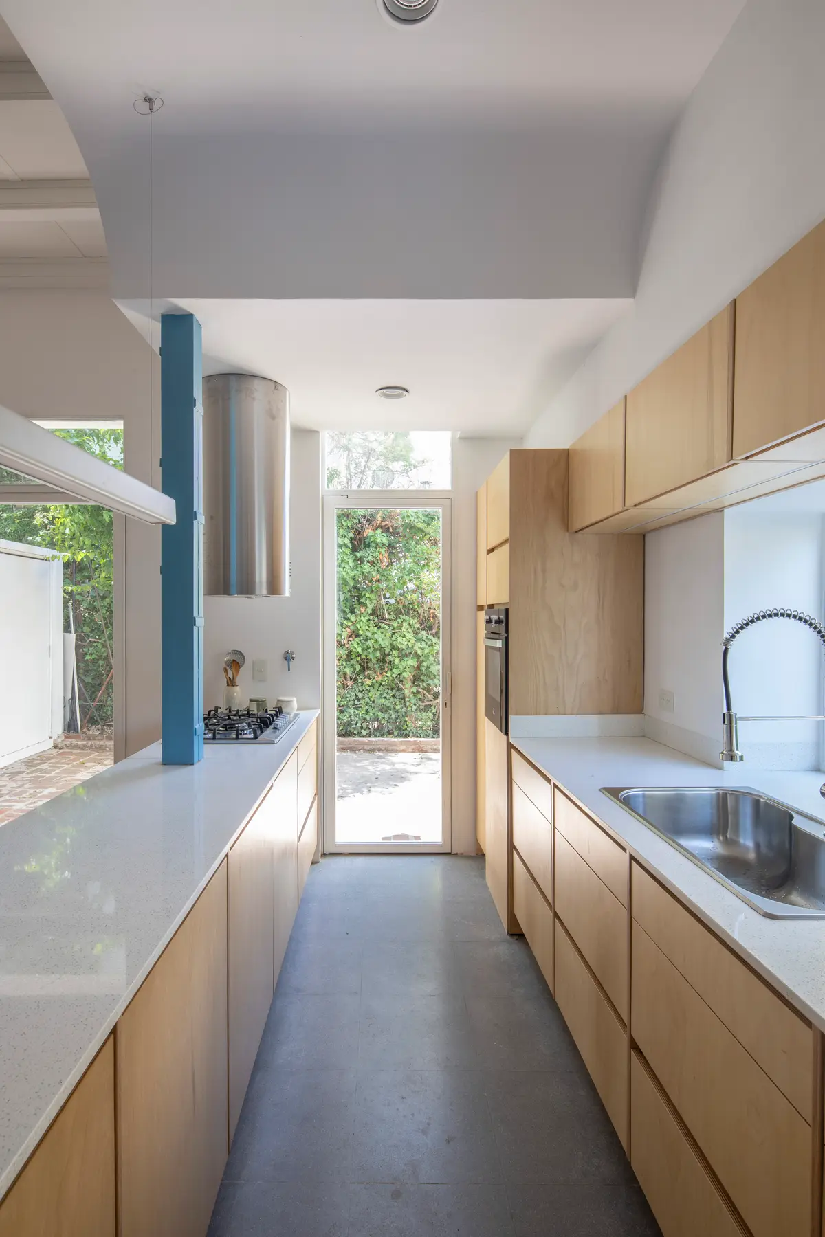 Cozinha moderna minimalista com luz natural e armários de madeira — projeto Reforma Alsina, por Estudio YME, em San Isidro
