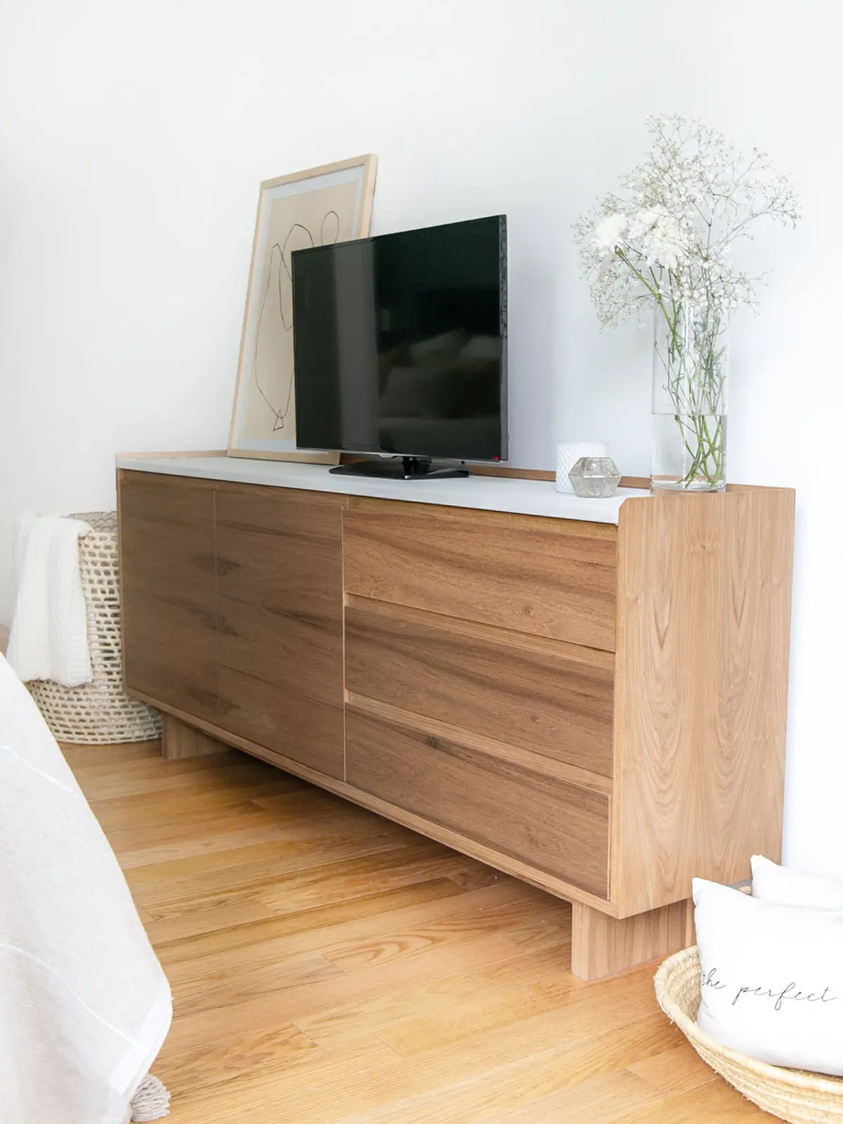 Móvel baixo de madeira clara com TV e arte minimalista — projeto Proyecto Cerviño, por Olivia D, em Palermo