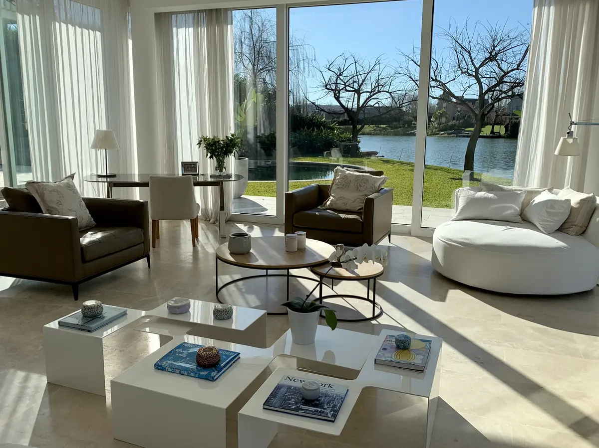 Living moderno con grandes ventanales y vista al lago — proyecto CASA LAGUNA, por Estudio Xime Fontan Balestra, en Tigre