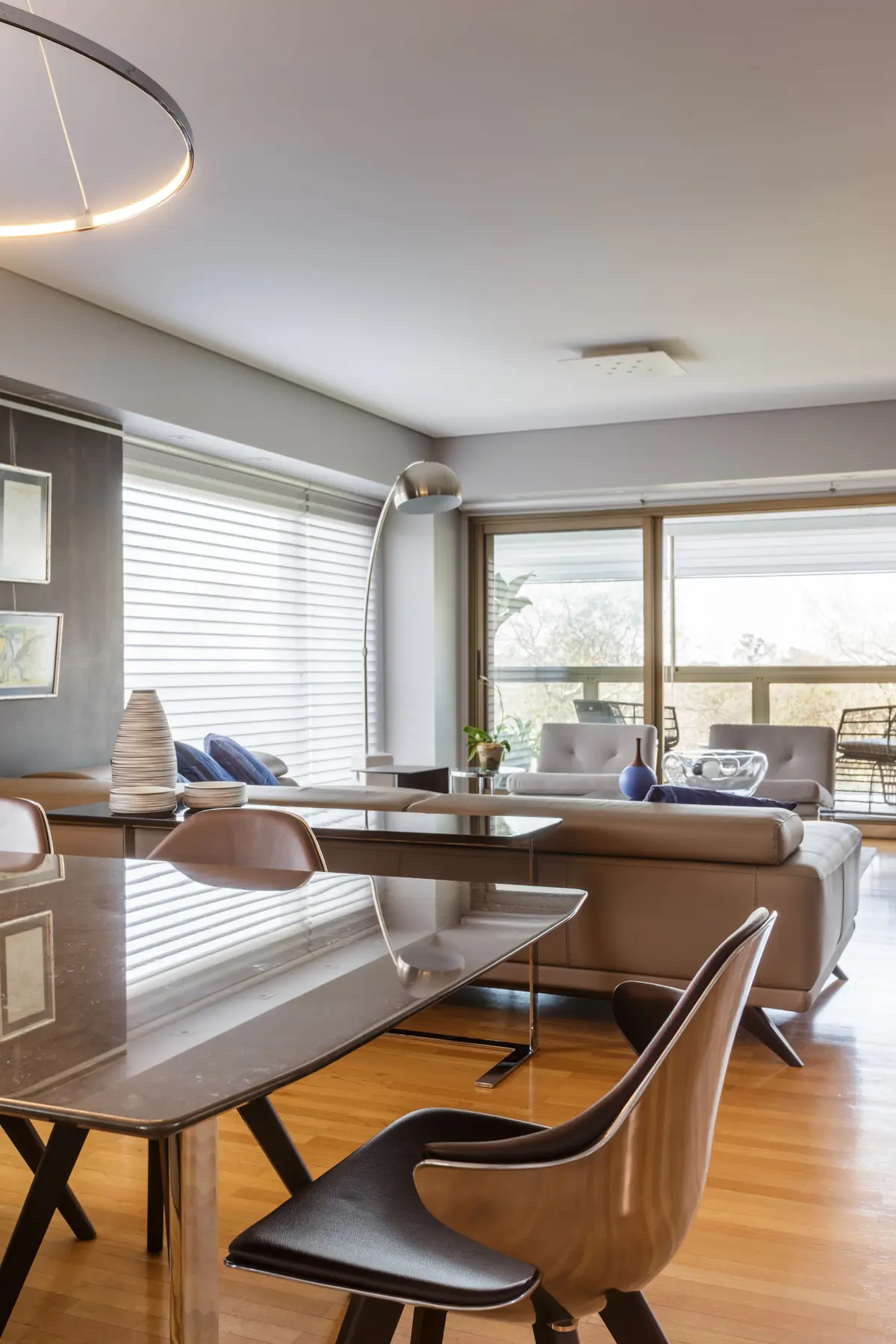 Living comedor moderno con sillón L, mesa de vidrio y sillas de madera — proyecto Piso en Belgrano, por Gutman+Lehrer Arquitectas, en Belgrano