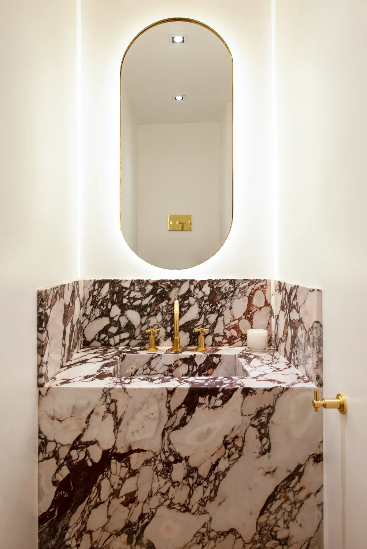 baño de lujo con mármol veteado y grifería dorada — proyecto Montevideo, por Parq Estudio, en CABA