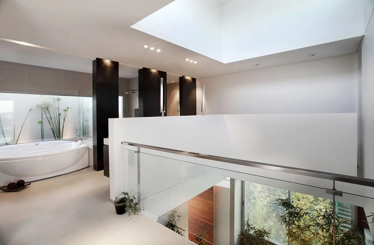Banheiro moderno de pé-direito duplo com banheira freestanding e claraboia — projeto Cabos, por Remy Arquitectos