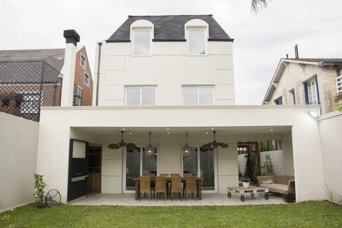 Fachada moderna con patio cubierto y comedor exterior — proyecto Casa Estilo Francés, por Estudio Fernandez Long & asoc., en Martínez