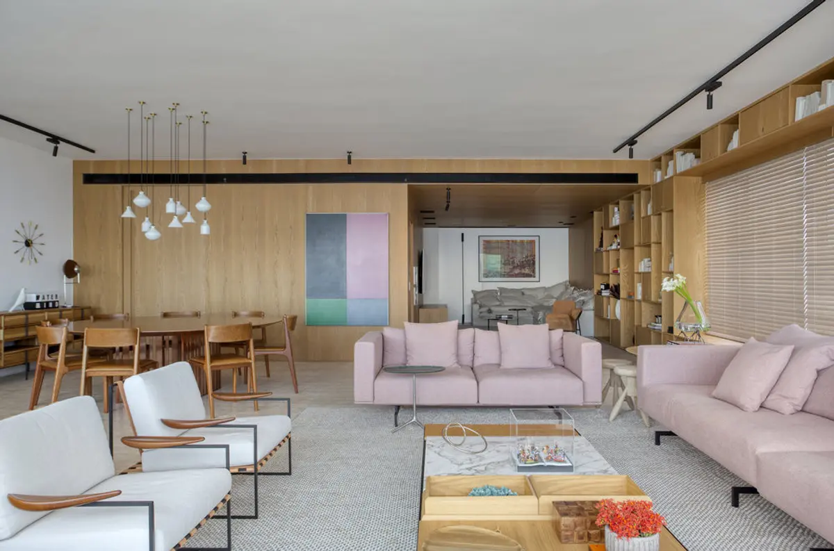 Living contemporáneo con sofás rosados, piso de madera y techo doble altura — proyecto PS House, por Studio Ro-ca
