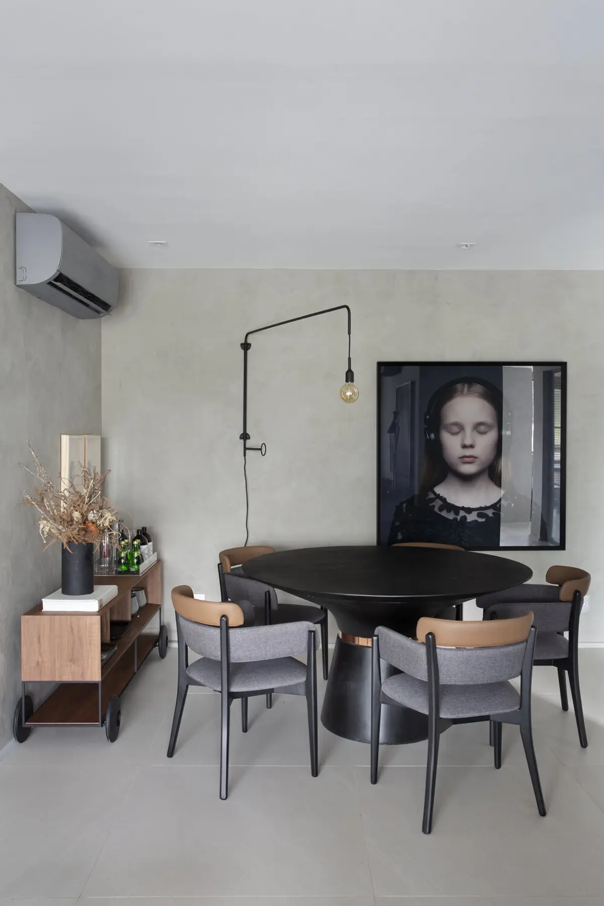 Comedor minimalista con mesa negra redonda y sillas grises tapizadas — proyecto Decorado Latitud, por Studio Ro-ca