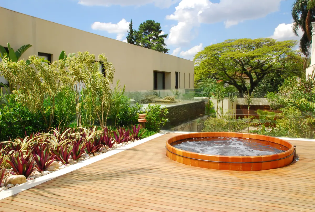 Patio moderno con pileta redonda naranja sobre deck de madera — proyecto Residência EC, por Gil Fialho