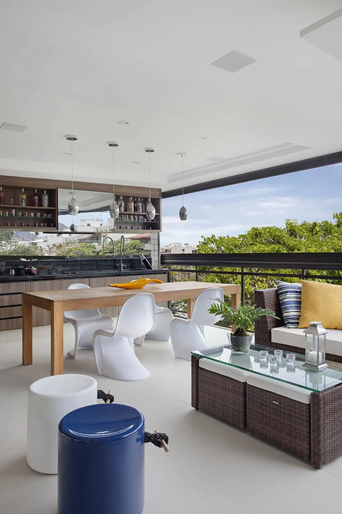 Terraza moderna con cocina integrada, vistas a verde y mobiliario contemporáneo — proyecto Apartamento Recreio, por Amanda Miranda